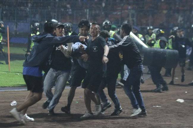 Sejumlah Aremania yang cidera dievakuasi usai polisi tembakkan gas air mata di dalam area Stadion Kanjuruhan.(foto: int) 